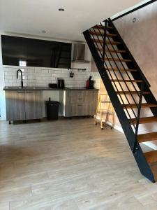 een keuken met een trap in het midden van een kamer bij Maison f2 avec cour privative in Montceau-les-Mines