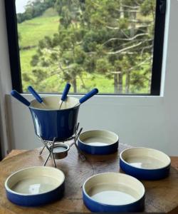 quattro ciotole su un tavolo di legno con una finestra di Terraços das Estrelas - Refúgio a 3 km do centro de Gonçalves! a Gonçalves