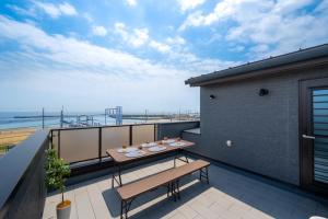 een balkon met een tafel en uitzicht op de oceaan bij Town House Suma in Kobe