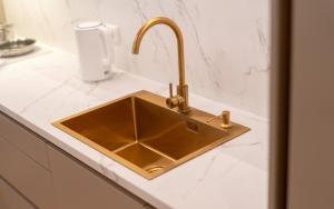 a kitchen counter with a gold sink in a bathroom at Lodja Suites in Tartu +46 photos