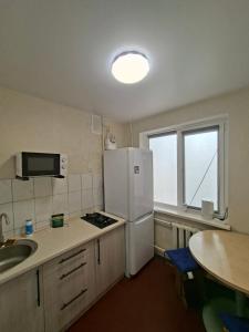 a kitchen with a white refrigerator and a sink at Cozy apartment in Kryvyi Rih