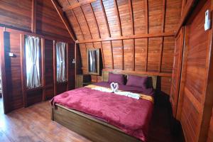 a bedroom with a bed in a wooden room at Laoceva vila in Padangnegeri