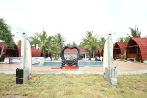 a sculpture in front of a pool with a surfboard at Laoceva vila in Padangnegeri