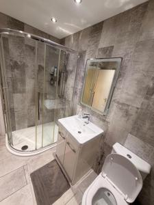 een badkamer met een douche, een toilet en een wastafel bij Adam Guest House in Leicester +15 foto's