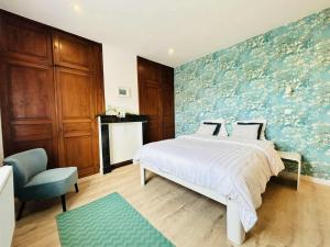 a bedroom with a bed and a blue wall at Vakantiehuis Cédric in mesen