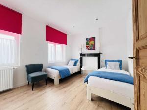 a bedroom with two beds and a chair at Vakantiehuis Cédric in mesen
