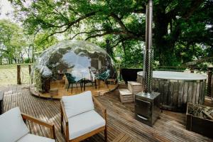 ein Iglu auf einer Terrasse mit Stühlen und einem Tisch in der Unterkunft les bulles perchées de lartigue in Margouët-Meymès