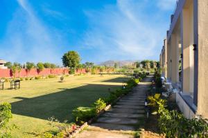 ein grasbewachsener Hof mit Treppe, die zu einem Gebäude führt in der Unterkunft Ranthambore Village Serai in Khilchīpur