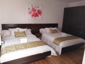 two beds sitting next to each other in a bedroom at San Jose hospedaje in Cuenca