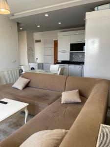 a living room with a brown couch and a kitchen at Flat in Samsun atakum in Atakum +5 photos