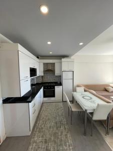 a kitchen with white cabinets and a table and chairs at Flat in Samsun atakum in Atakum