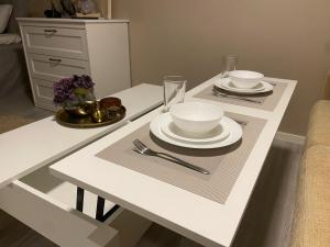 a white table with plates and bowls on it at Boende i Falkenberg in Falkenberg