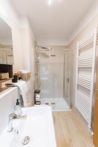 een witte badkamer met douche en wastafel bij Apartma Castrum Vini in Ajdovščina