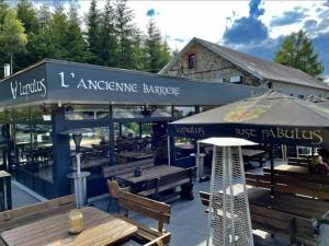 a restaurant with tables and an umbrella and benches at DeerN'Wood in Trois-Ponts