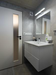 een badkamer met een witte wastafel en een spiegel bij Apartment Brno-Lesná 