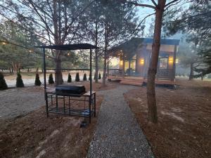a small house with a grill in a park at Equi Lis - будиночки для відпочинку in Yasnogorodka