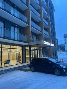 een zwarte auto geparkeerd voor een gebouw bij Vista Studio in Bakuriani