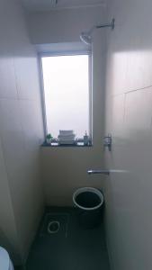 a small bathroom with a window and a toilet at NXone STUDIO APARTMENT in Noida