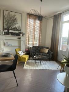 ein Wohnzimmer mit zwei Stühlen und einer Couch in der Unterkunft Studio avec grande terrasse in Saint-Valéry-en-Caux