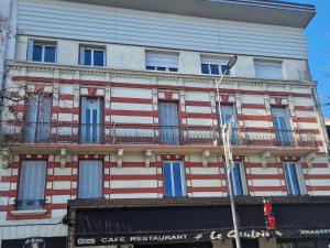 a red white and blue building with a balcony at Le 105 BIS in Vichy