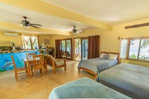 een slaapkamer met twee bedden en een tafel en stoelen bij Hotel Playa Reina in Llano de Mariato +48 foto's