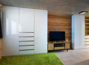 een woonkamer met een grote witte muur waarop een televisie staat bij Apartment Brno-Lesná 