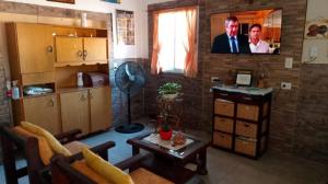 un soggiorno con una TV su un muro di mattoni di Todos los santos 590 a Miramar