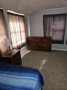Schlafzimmer mit einem Bett, einer Kommode und Fenstern in der Unterkunft Place to stay in Lawton