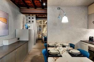 a kitchen with a dining table and blue chairs at Marina Vista Apartment in Riomaggiore