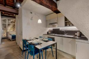 a kitchen with a table and blue chairs in a kitchen at Marina Vista Apartment in Riomaggiore