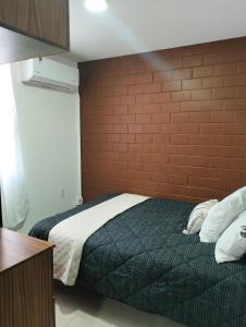 una camera da letto con un letto con un muro di mattoni di Departamento Villas Doradas a Santa Cruz Huatulco Altre 10 foto