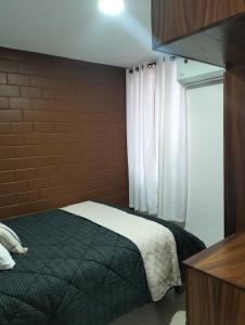 una camera da letto con un letto nero e una finestra di Departamento Villas Doradas a Santa Cruz Huatulco