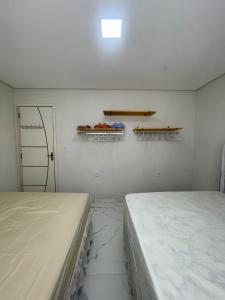 two beds in a room with shelves on the wall at Brisa Mar in Canavieiras