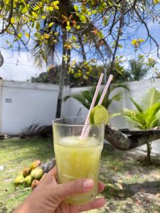 a person holding a drink with a lime at Brisa Mar in Canavieiras
