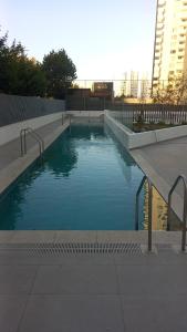 a swimming pool with blue water in a city at Concón Apartment in Concón