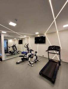 a gym with three treadmills and cardio machines at Concón Apartment in Concón