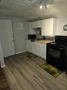 eine Küche mit weißen Schränken und einem schwarzen Herd in der Unterkunft Place to stay in Lawton