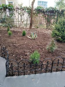 un jardin avec une clôture en fer noir et des plantes dans l'établissement HEBRANGOVA Apartman, à Drljanovac