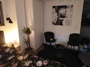 une chambre avec deux chaises, un lit et un poster dans l'établissement HEBRANGOVA Apartman, à Drljanovac