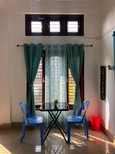a table and two blue chairs in a room at Green Stay , AC room in Sibsāgar