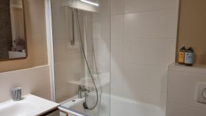 een douche met een glazen deur naast een wastafel bij Studio Roy Gradlon Quimper in Quimper