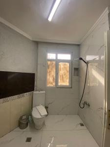 a white bathroom with a toilet and a window at Divan Wooden Guesthouse in Istanbul