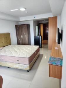 a bedroom with a bed and a television in it at Khodijah Homestay in Medan