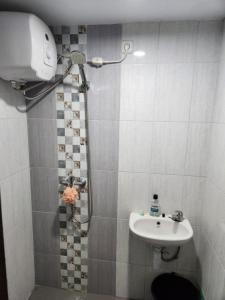 a small bathroom with a sink and a shower at Khodijah Homestay in Medan