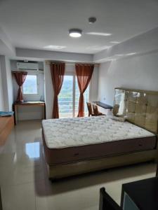 a bedroom with a large bed in front of a window at Khodijah Homestay in Medan