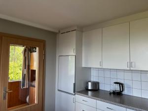 a kitchen with white cabinets and a refrigerator at Sunset View Apartment Bregenz Bodensee in Bregenz +14 photos