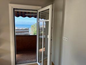 a door to a balcony with a view of the ocean at Sunset View Apartment Bregenz Bodensee in Bregenz