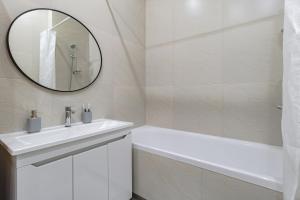 a white bathroom with a sink and a mirror at Мандаринка in Taldykolʼ +19 photos