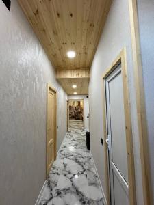 a hallway with a marble floor and wooden ceilings at Дома в Дилижане in Dilijan