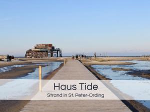 a boardwalk on the beach with the words hulse tribe stand in st st at Entspannter Nordsee-Urlaub in naturnahen Ferienwohnungen im Haus Tide in Böhl